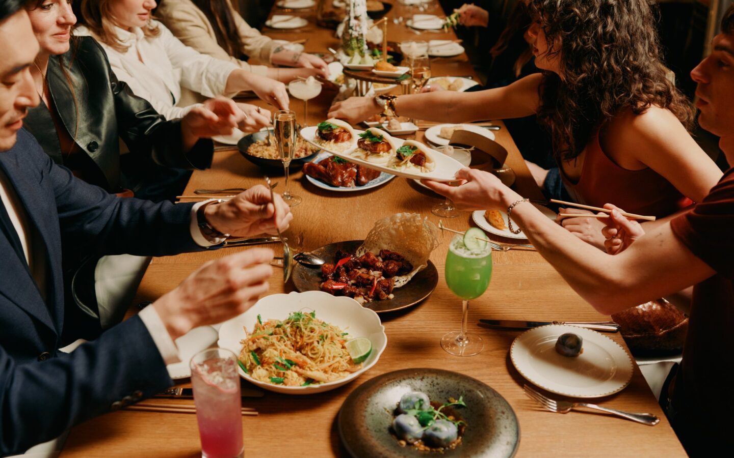Guests sharing a family-style banquet at a long table in a Starr Restaurants venue